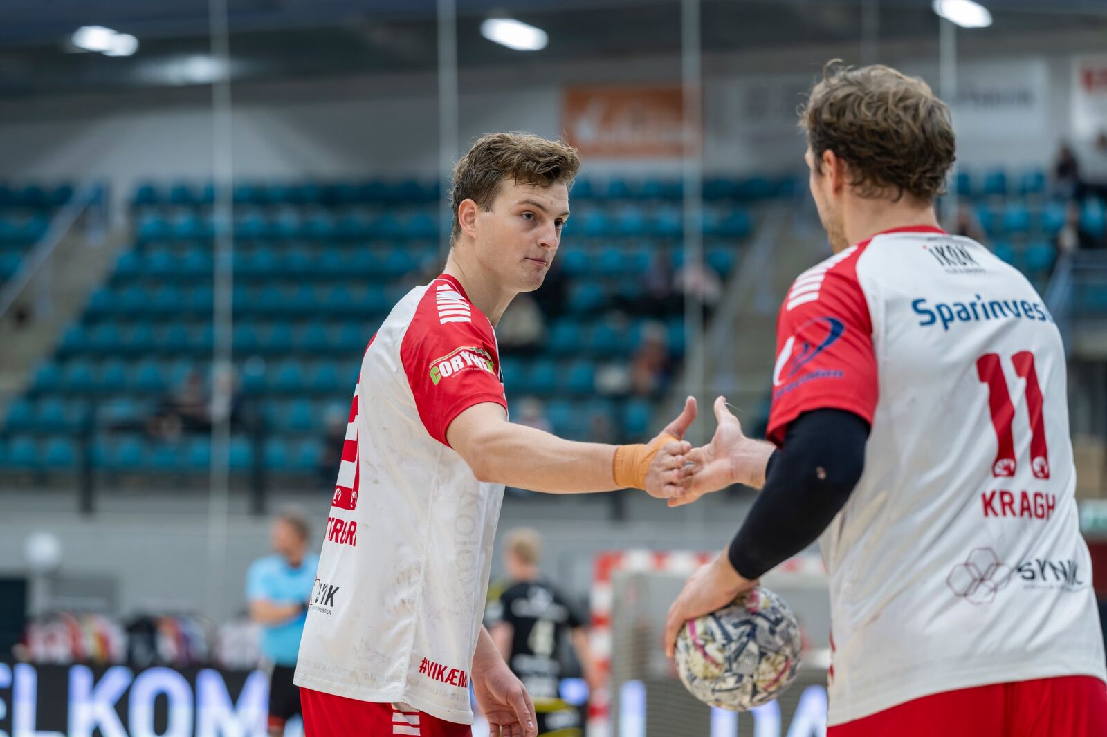 To KIF-spillere giver hinanden hånd
